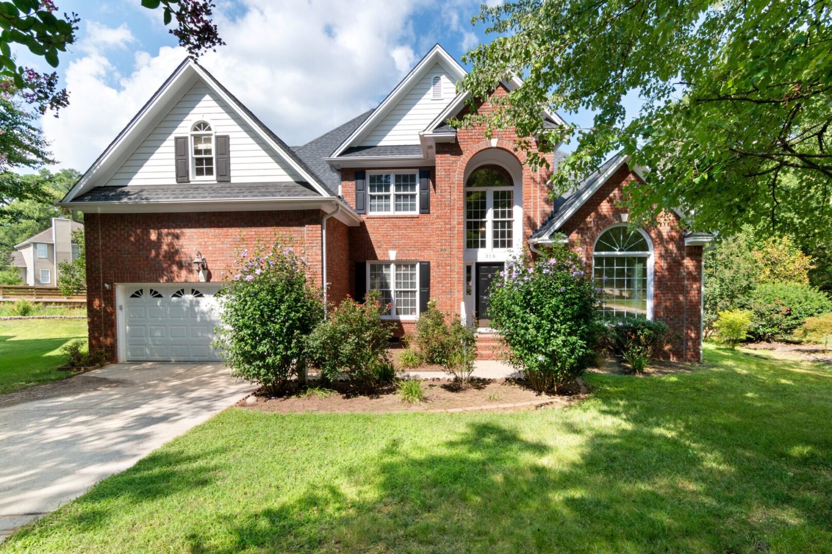 A large brick house with a lot of trees around it